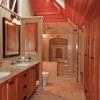 View inside new master bath shows built-in storage below eaves.  Skylights and high windows bring borrowed light into dressing area and stairwell. Shower on far wall includes a limestone niche and bench.