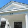 Classical details are modest and appropriate for a cottage.  Door now aligns with front wall, and includes bullseye glass in top lights.  Paneling between pilasters suggests an outdoor room.