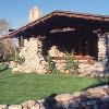 Front porch faces southeast.  This view shows reconstructed boulder columns, chimney and base.  Porch roof framing was also reconstructed by Ken Rideout and crew.